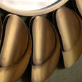 Close-up of elegant gold petal-inspired mirror decor with soft reflective texture.