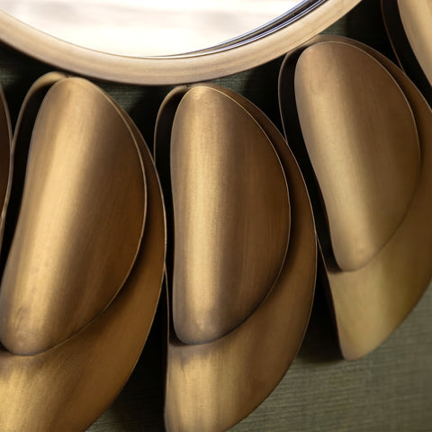 Close-up of elegant gold petal-inspired mirror decor with soft reflective texture.