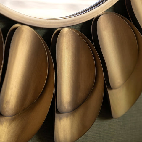 Close-up of elegant gold petal-inspired mirror decor with soft reflective texture.