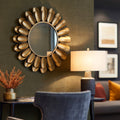 Luxury wall mirror with layered gold petal frame in a sophisticated modern living space.