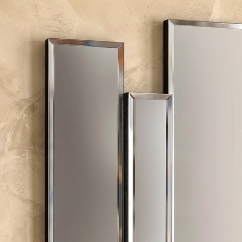 Close-up detail of decorative vertical mirror installation with reflective metallic finish.