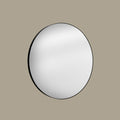 Round mirror with black frame on a beige background