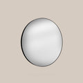 Round mirror with black frame on a beige background