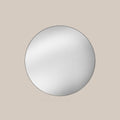 Round mirror on a beige wall
