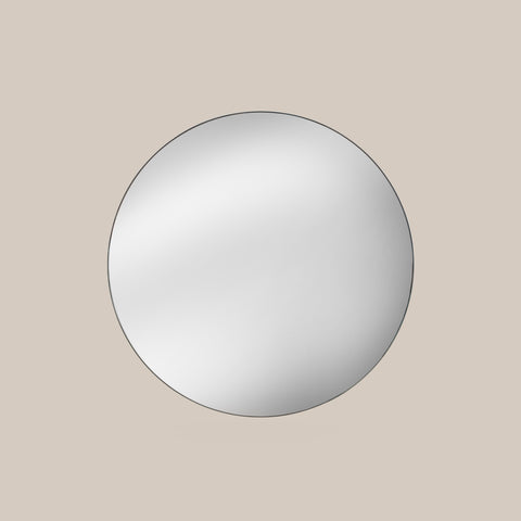 Round mirror on a beige wall