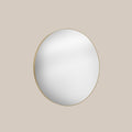 Round mirror with gold frame on a beige background