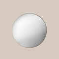 Round Champagne gold mirror on a beige wall