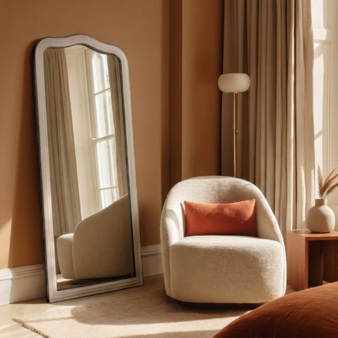 Elegant grey leaner mirror with a gently shaped top and vintage-inspired distressed detailing.