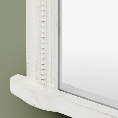 Detailed view of a textured white mirror frame with decorative beaded trim and soft distressed accents.
