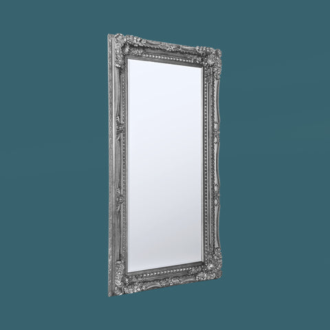 Decorative standing floor mirror with ornate silver frame and classic carved accents.