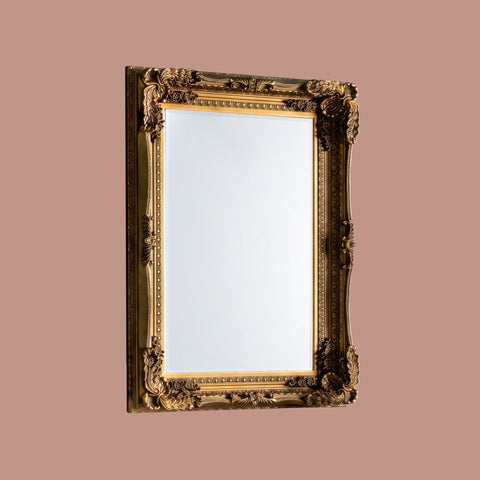 Elegant vintage-style mirror with decorative gold frame and elaborate ornamental carvings.