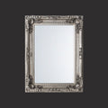 Elegant vintage-style mirror with decorative silver frame and elaborate ornamental carvings.