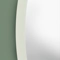 Contemporary circular wall mirror with smooth white trim and understated minimalist aesthetic.