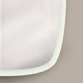 Close-up of a sleek white framed mirror featuring soft organic curves and understated design.