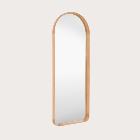 leaner mirror with a oak frame at an angle on a light grey background