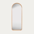 leaner mirror with a oak frame on a light grey background