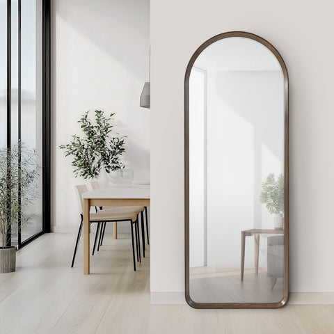 Large arched walnut mirror in a modern interior setting with a dining table and chairs.