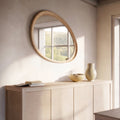 Huxley pebble wall mirror with oak frame above sideboard in modern living room