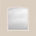 White wood framed over-mantel mirror on a beige wall