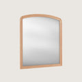 Huxley Oak-framed mirror set at an angle on a light grey background