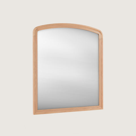 Huxley Oak-framed mirror set at an angle on a light grey background