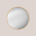 Round oak framed mirror on a beige background