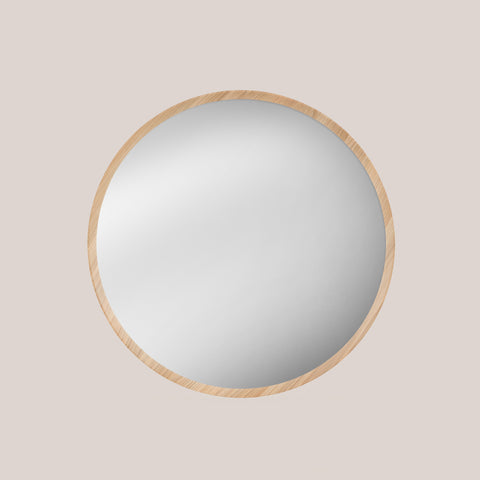 Round oak framed mirror on a beige background