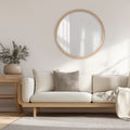 Modern living room with a beige sofa, round oak framed wall mirror, and side table.