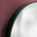 Close-up of a back framed mirror on a maroon background