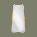 Rectangular organic shaped leaner mirror with gold effect frame on a light green background face on