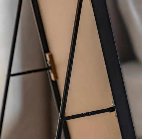close up of the back of a black framed cheval mirror