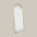 cheval arched mirror with gold frame on a beige background
