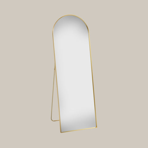 cheval arched mirror with gold frame on a beige background