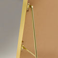 Back of a arched gold framed cheval mirror showing the stand arms