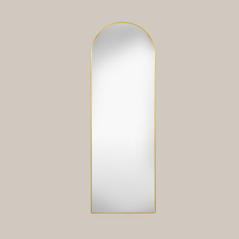 cheval arched mirror with gold frame on a beige background face on