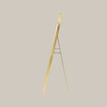 cheval arched mirror with gold frame shown from the side angle on a beige background