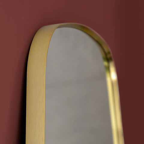 Gold-framed mirror on a red wall