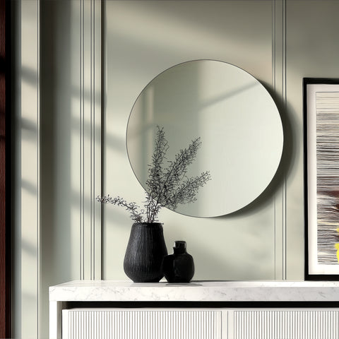 Round wall mirror styled within a modern living space, adding simplicity, balance and subtle reflective depth.