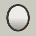 Contemporary round mirror with a textured black frame and subtle gold-toned inner detailing.