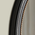Close-up of a contemporary round mirror frame highlighting layered texture, subtle metallic warmth and decorative detailing.