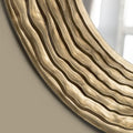 Close-up of a textured circular mirror frame highlighting layered organic lines, subtle metallic ageing and soft sculptural depth.