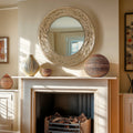 Textured round wall mirror styled above a fireplace, featuring layered sculptural detailing that adds warmth, depth and soft reflective light to the space.