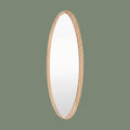 Oval wall mirror with a slim natural wood frame and minimalist contemporary design against a muted green background.
