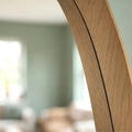 Detailed view of a wooden-framed oval mirror with smooth curved edges and modern styling.