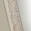 Vintage-inspired mirror frame showcasing textured distressing, ornate carved accents and delicate raised beading.