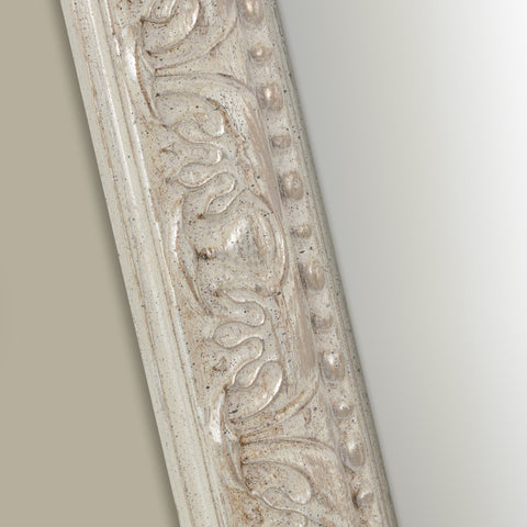 Vintage-inspired mirror frame showcasing textured distressing, ornate carved accents and delicate raised beading.