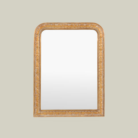 Decorative gold mirror with an ornate carved frame, showcasing intricate scroll detailing and a classic arched design.