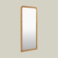 Elegant arched leaner mirror with a decorative gold frame, highlighting intricate carved patterns and a refined traditional finish.
