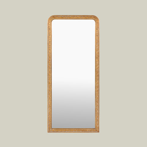 Traditional gold leaner mirror featuring an intricately carved frame with elegant decorative detailing and softly rounded corners.