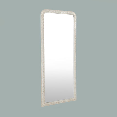 Ornate leaner mirror with an intricately carved frame, featuring decorative scroll detailing and a timeless arched silhouette.